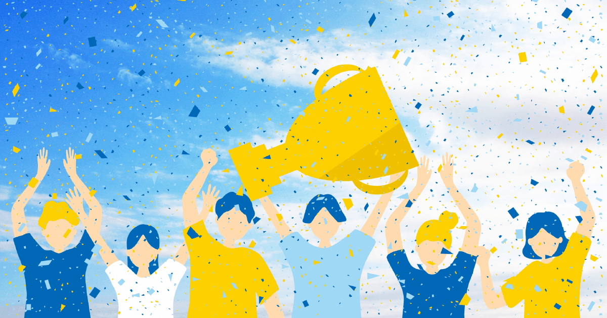 優勝カップを持つ人とお祝いする人