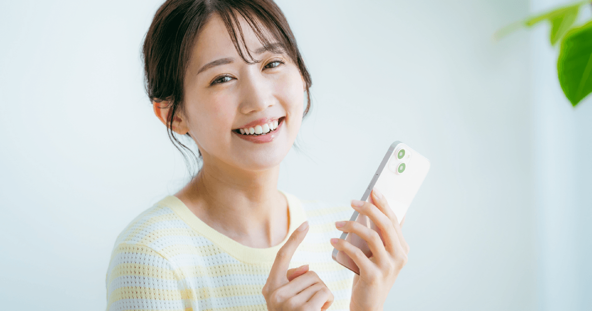 笑顔でスマホを見る女性