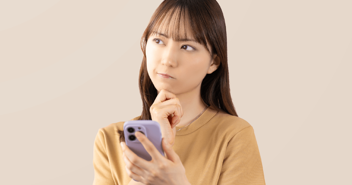 スマホを見て考える女性