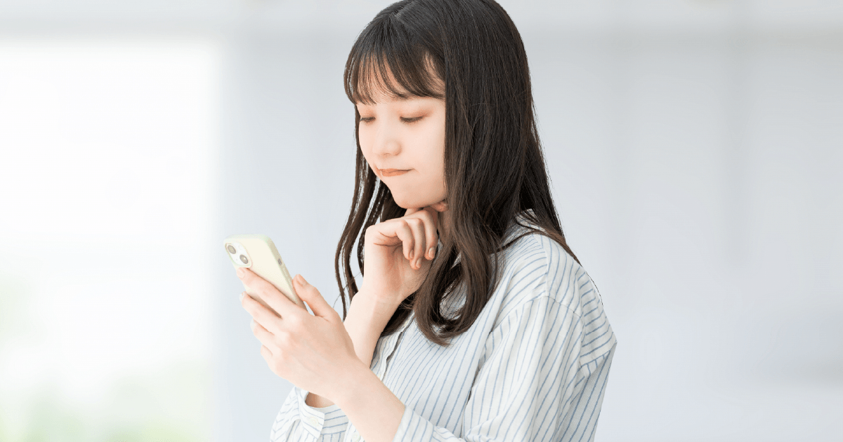 スマホを見て考える女性