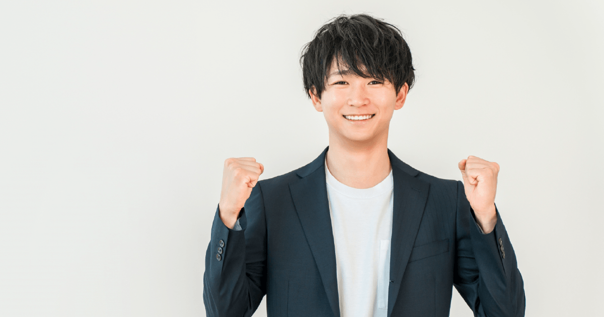 カジュアルスーツでガッツポーズをする男性