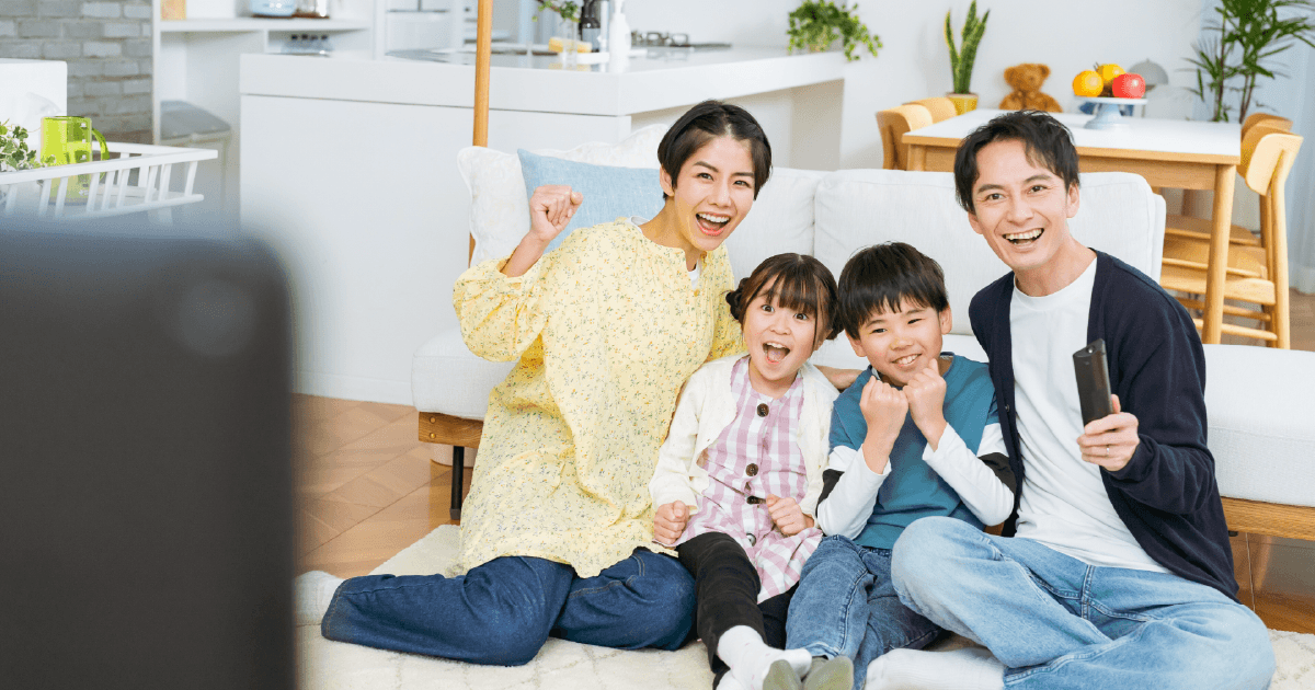 楽しそうにテレビを見る家族