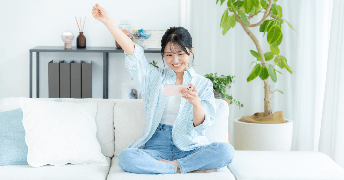 スマホを見ながら応援する女性
