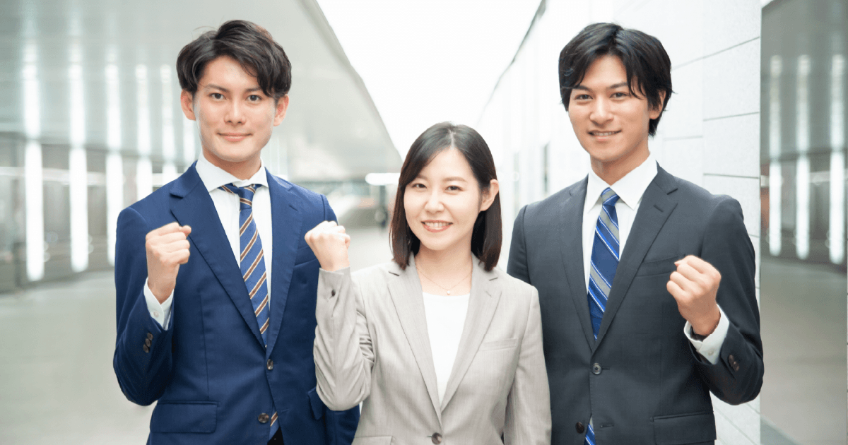 スーツを着てガッツポーズをする男女