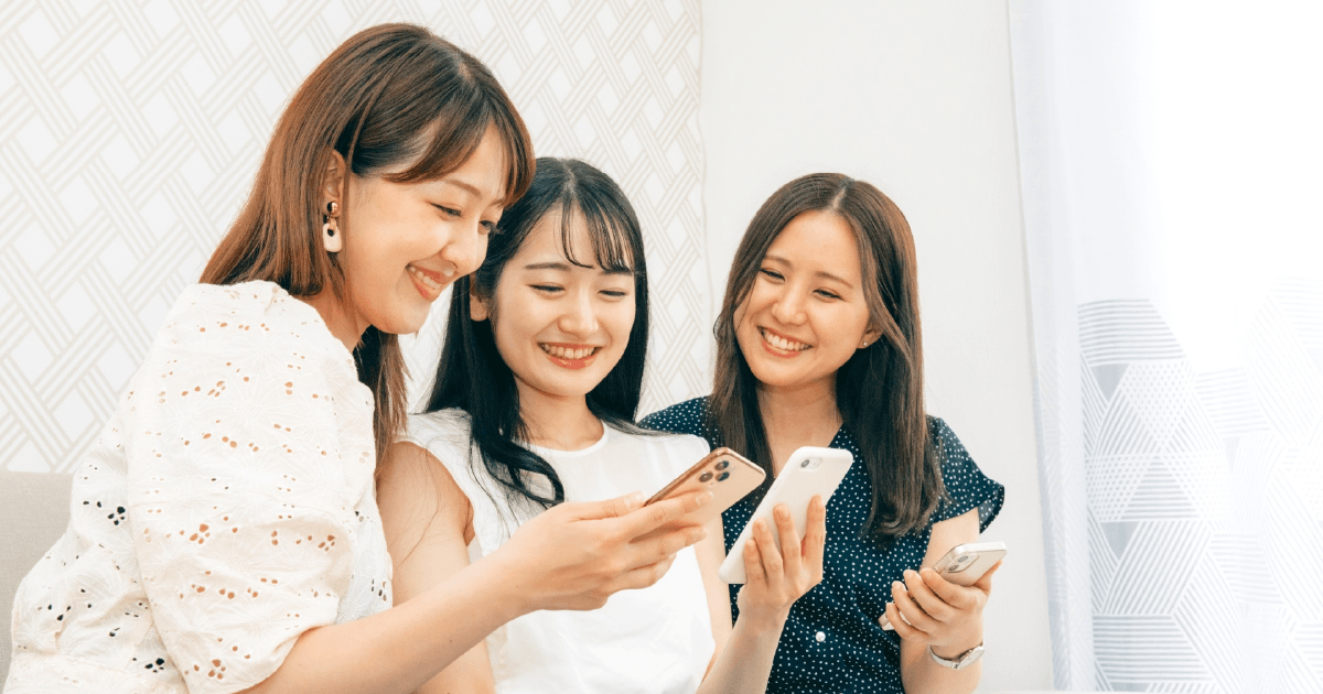 スマホを一緒に見る女性3人