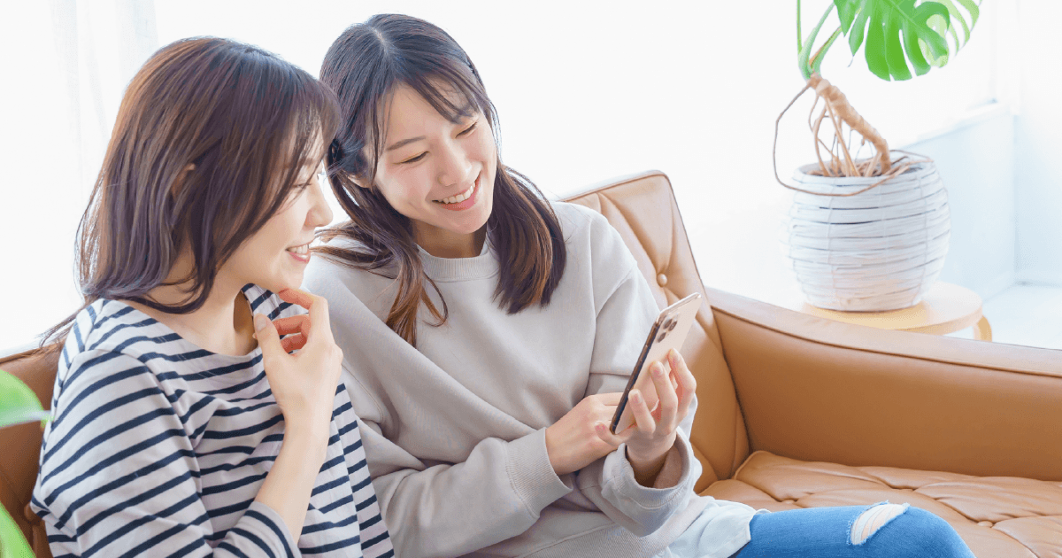スマホを一緒に見る女性2人