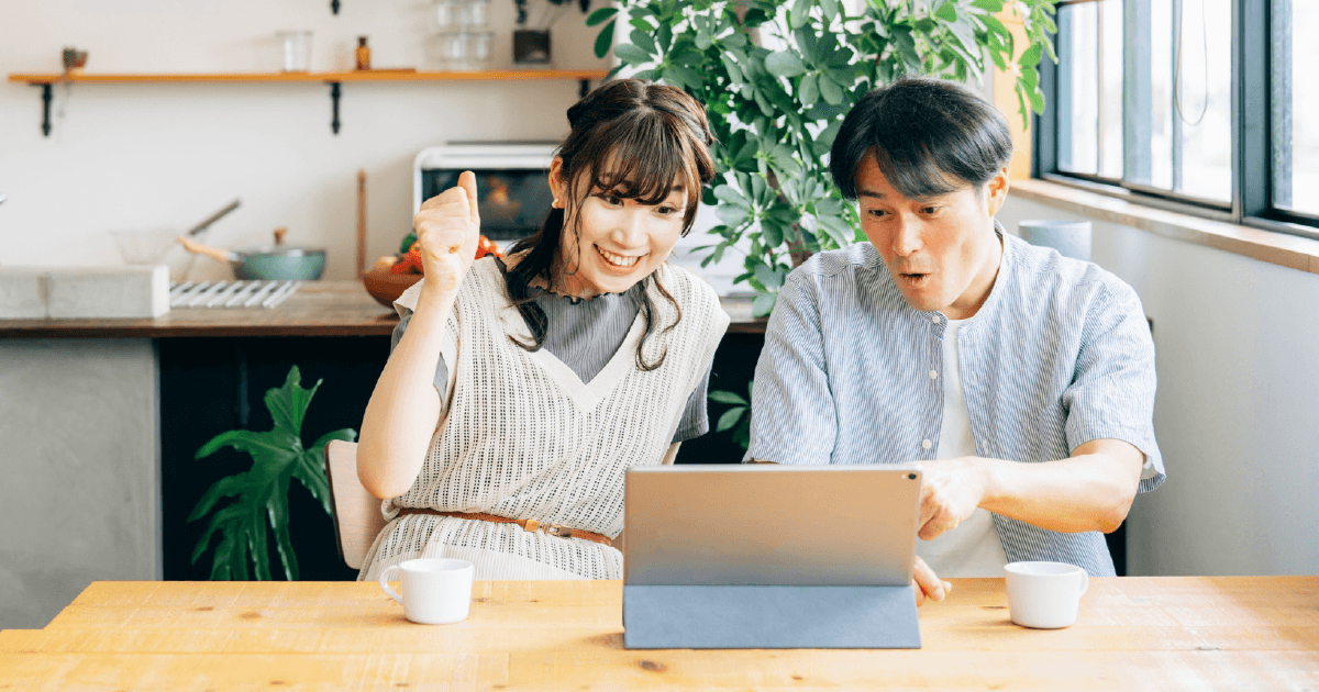 タブレットを見ながら応援する夫婦