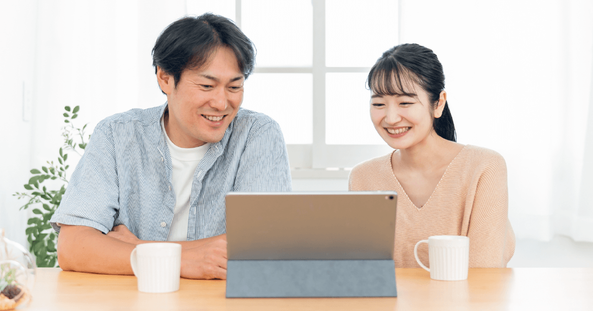 楽しそうにタブレットを見る夫婦