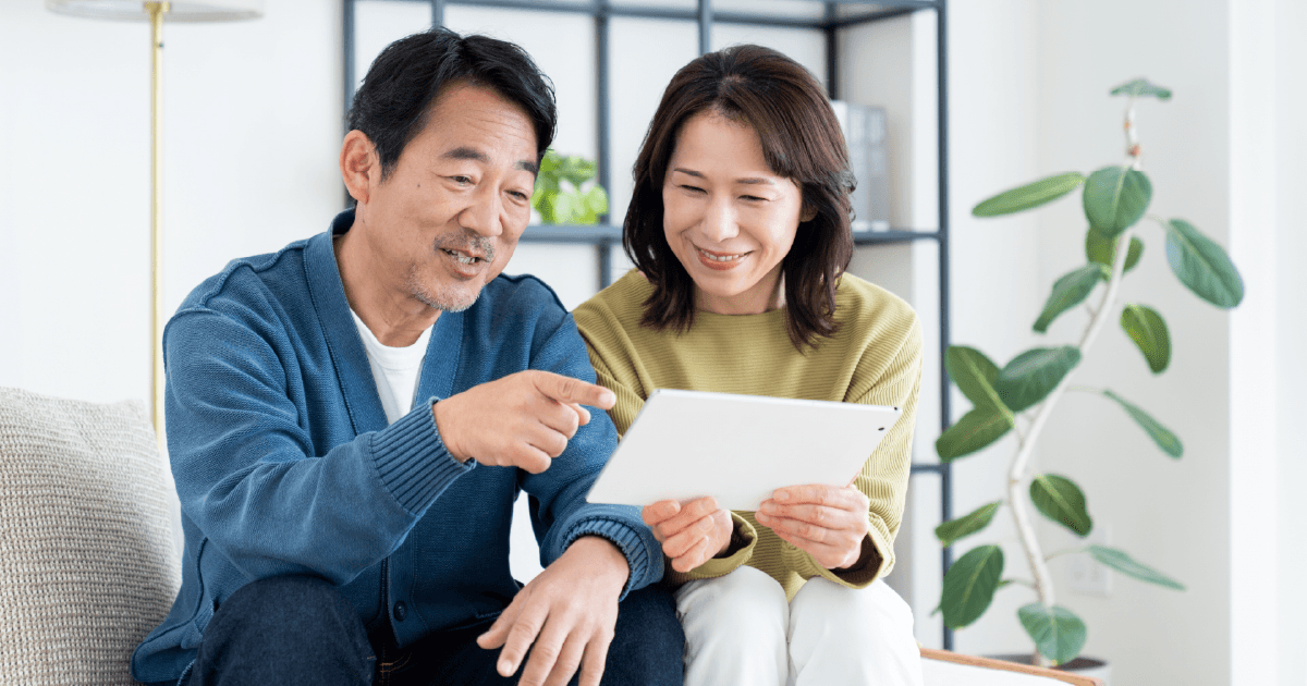 楽しそうにタブレットを見る夫婦
