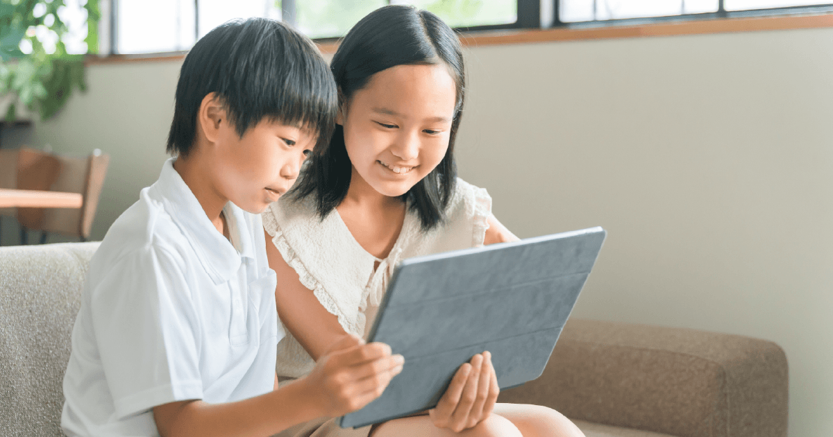 楽しそうにタブレットを見る子供たち
