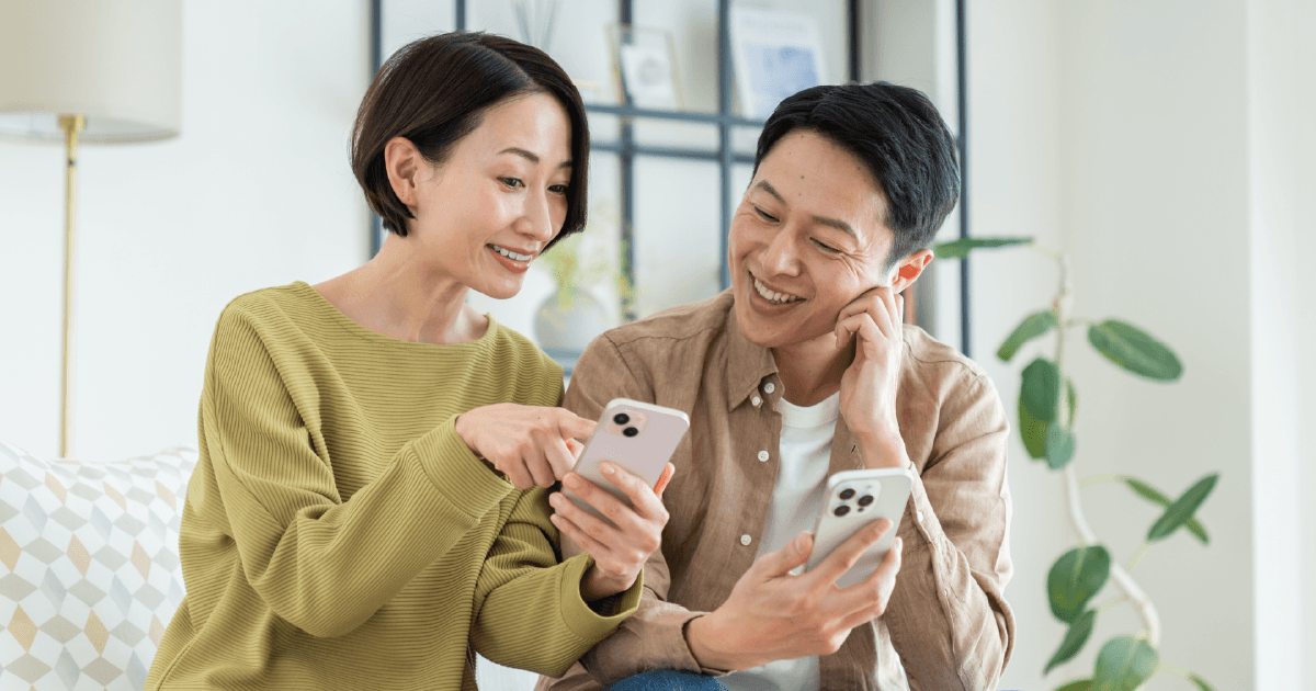楽しそうにスマホを見る夫婦